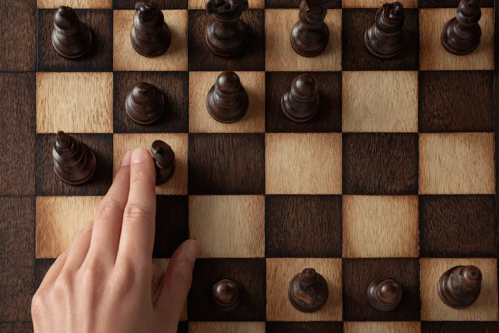 A womans hand making the first move in chess a metaphor for what is an Opening Move on Bumble