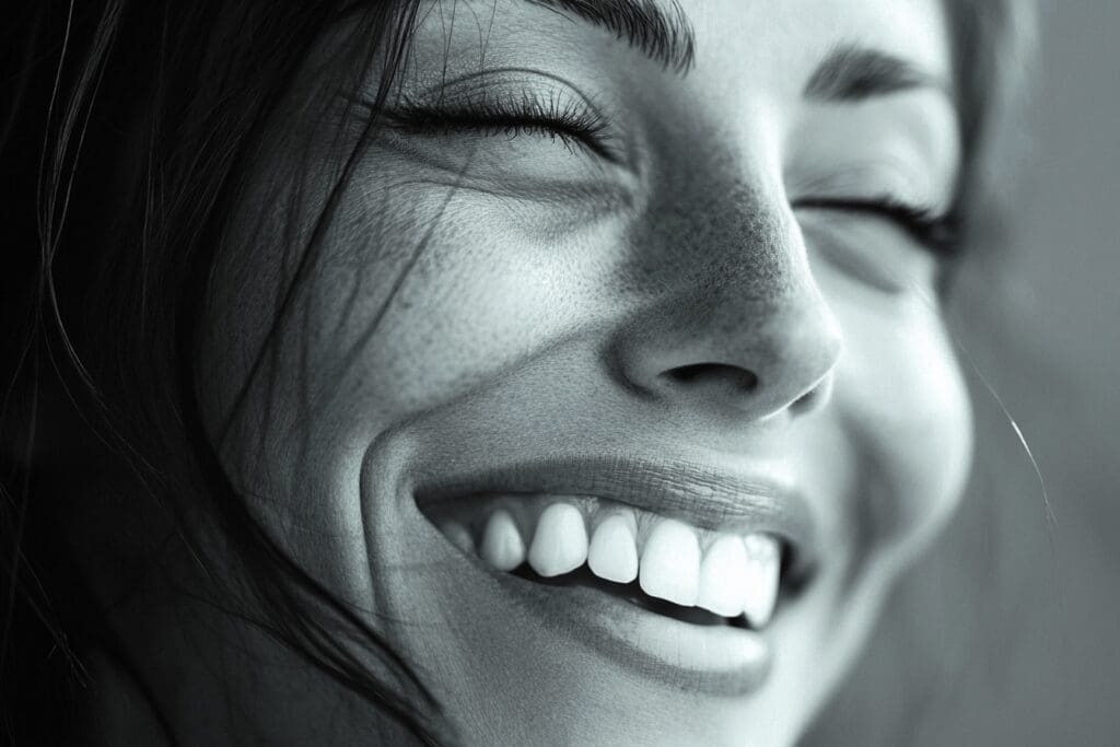 Woman smiling with eyes closed and freckles.